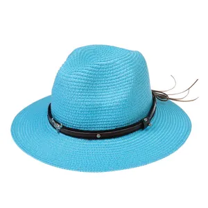 Détail du chapeau de paille turquoise avec bande en cuir brun et motif tête de taureau