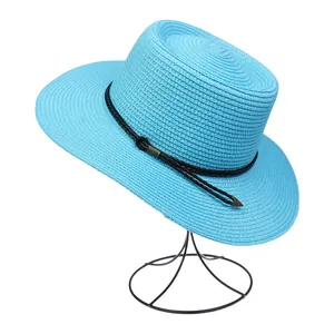 Detail view of the blue straw sun hat with black woven band and metal tip accents
