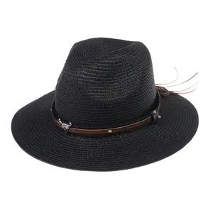 Détail du chapeau Panama noir avec bande en cuir marron et ornement de crâne de taureau