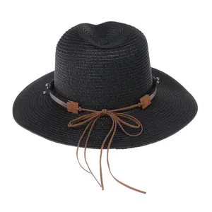 Détail d'un chapeau Panama noir tissé avec un ruban en cuir, un nœud et des glands fins