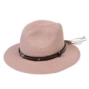 Détail du chapeau Panama rose avec ruban en cuir, clous dorés et pendentif tête de taureau