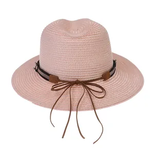 Détail du chapeau Panama rose en paille tressée avec ruban noir et cuir élégant