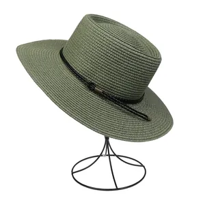 Detail view of olive green straw hat with flat top and black woven decorative band