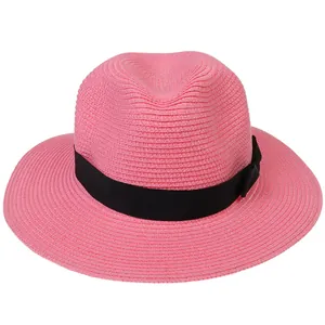 Détail du chapeau Panama tissé rose avec bord large et ruban classique en gros-grain noir