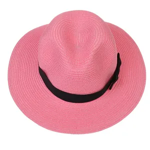 Détail d'un chapeau Fedora en paille rose avec ruban en gros-grain noir et nœud décoratif