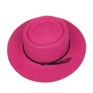 Detailed top view of a hot pink boater straw hat with black string and metal buckle