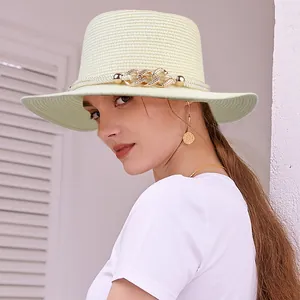 Eleganter beiger Strohhut mit goldener Kette und Perlen für Damen im Sommer