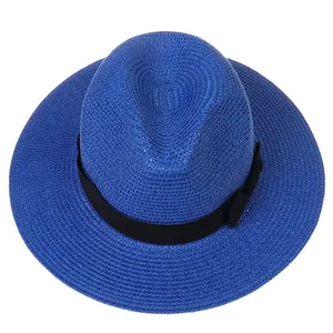 Détail d'un chapeau Panama bleu roi en paille avec ruban noir et nœud latéral élégant