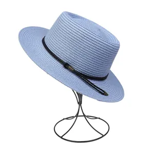 Close-up of light blue woven straw sun hat featuring a fedora style and black decorative band