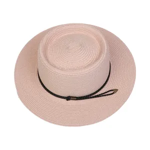 Detailed macro view of pink straw sun hat texture with black cord and gold metallic tips