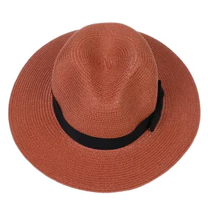 Détail d'un chapeau de paille Panama rouge brique avec ruban gros-grain noir sur blanc