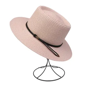 Detail of light pink wide brim straw hat with woven cord and arrow pendant decoration