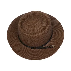 Top-down view of dark brown straw boater hat with black cord and gold metal tips