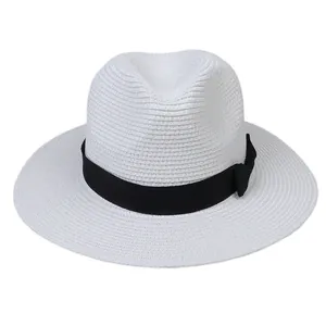 Détail du chapeau Panama tressé blanc avec ruban gros-grain noir et décoration nœud