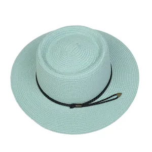 Detail of mint blue straw hat featuring black woven rope and gold metal accents