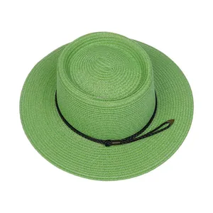 Detailed top view of light green straw boater hat with black decorative cord and metal tips