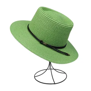 Detail of woven straw texture and black decorative band on grass green summer hat