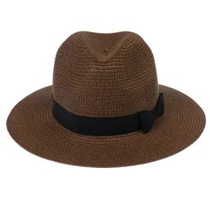 Détail d'un chapeau Panama marron tressé avec un ruban décoratif noir en gros-grain