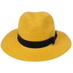 Détail du chapeau Panama jaune avec texture tissée en spirale et ruban noir élégant