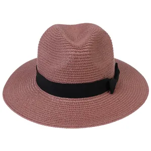 Détail du tissage en paille de papier et du ruban noir avec nœud sur le chapeau Panama rose