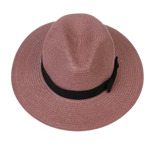 Détail d'un chapeau Panama rose avec texture tissée fine et ruban gros-grain noir à nœud
