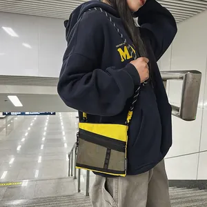 Waterproof yellow nylon crossbody bag with black mesh pocket and braided shoulder strap