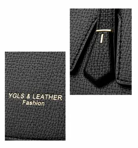 Vue détaillée de la texture du cuir grainé noir et des ferrures dorées du sac à main