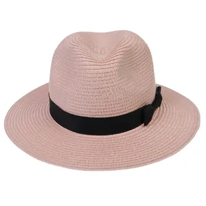 Détail d'un chapeau Panama rose avec texture de paille fine et ruban noir élégant
