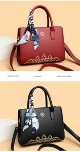 Detail of cowhide leather handbags featuring golden embroidery and kangaroo metal logo