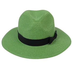 Détail de la texture tressée et du ruban noir à nœud sur ce chapeau Panama vert élégant