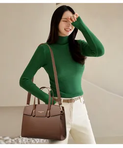 Détail du sac en cuir litchi marron foncé avec ferrures dorées et bandoulière réglable