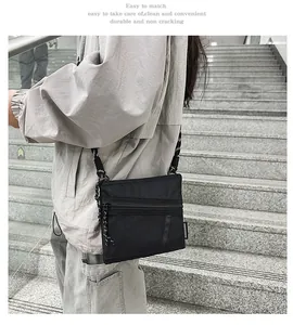 Detail view of black nylon crossbody bag with mesh pocket and adjustable woven rope strap