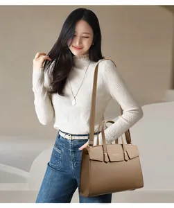 Détail d'un sac à main en cuir marron foncé à grain litchi avec fermoir métallique doré