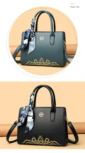 Detail of elegant handbags featuring gold embroidery, kangaroo logo and silk scarf handles