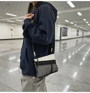 Detail of a mesh crossbody bag with dual-tone rope strap on a model in urban setting