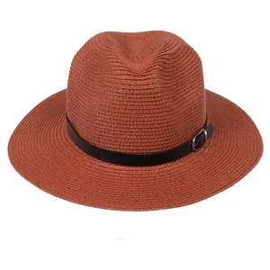 Détail du chapeau Fedora en paille tressée rouge brique avec ruban en cuir et boucle métallique