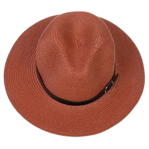 Détail d'un chapeau Panama orange brûlé avec texture de paille fine et bande en cuir noir à boucle