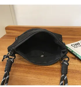 Macro view of black nylon messenger bag showing interior compartment and rope strap