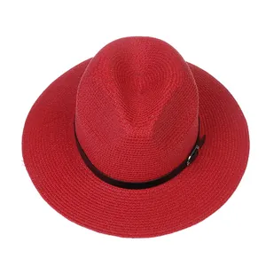 Détail du chapeau Panama rouge montrant la texture tressée et la bande en cuir noir