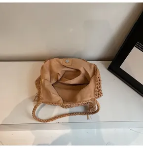 Detail of woven straw tote bag interior showing fabric lining and magnetic closure