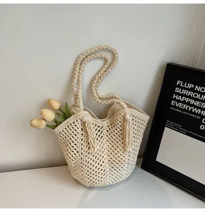 Detailed close-up of cream handmade crochet tote bag featuring hollow weave and long tassels