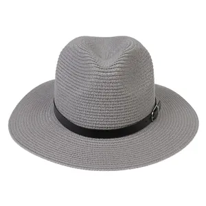 Détail du chapeau Panama gris avec texture tissée fine et ceinture en cuir noir à boucle métal