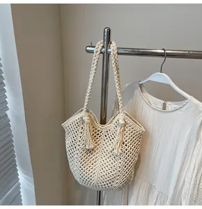 Detailed close-up of cream handmade woven tote bag with fringe tassels and rope handles