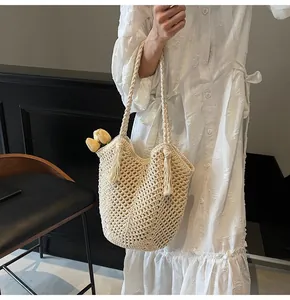 Detailed close-up of handmade woven tote bag with fringe tassels and hollow knit pattern