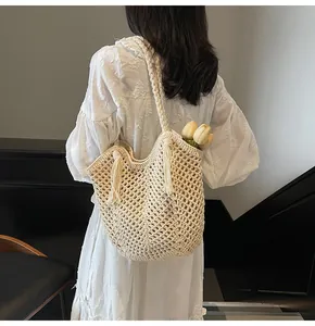 Detail shot of the cream hollow crochet tote bag featuring fringe tassels and woven texture