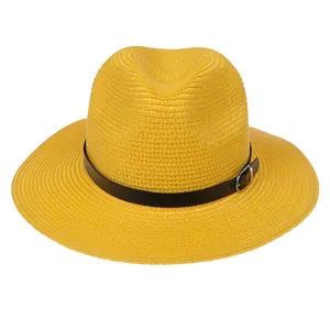 Gros plan détaillé de la paille tressée jaune avec ruban en cuir noir et boucle argentée