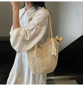 Close-up of cream crochet tote bag with hollow mesh design and tassel detail