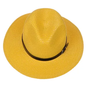Détail d'un chapeau Panama jaune avec paille tressée et ruban en cuir noir à boucle métal