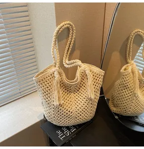 Macro detail of beige crochet tote bag featuring handcrafted mesh weave and long tassels