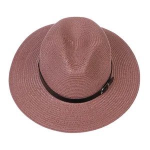 Vue de dessus d'un chapeau Panama rose tissé avec ruban noir et boucle métallique détaillée